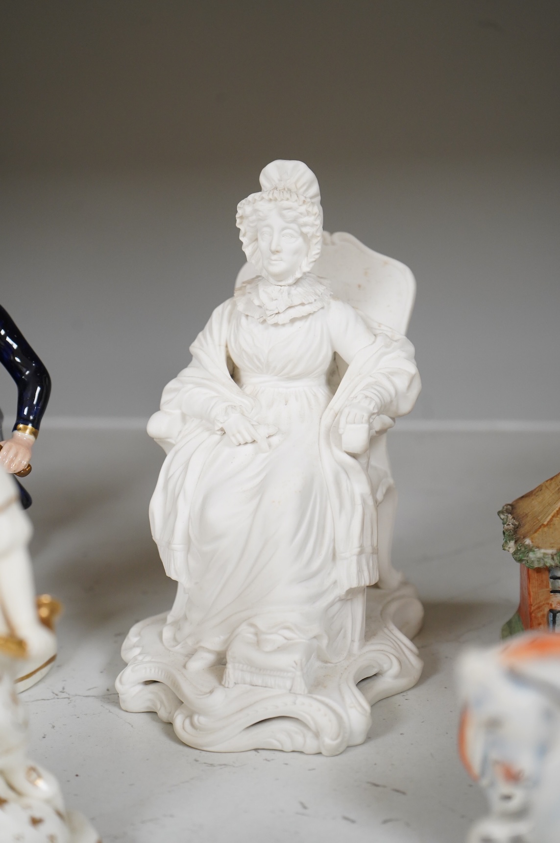A group of mid-19th century Staffordshire porcelain figures, two models of zebras and a early 19th century Derby biscuit porcelain figure of a seated lady, largest 18cm high
